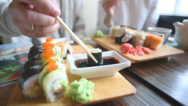 一对幸福的夫妇在日本餐厅吃寿司卷视频素材