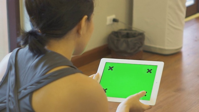 女性使用绿色屏幕的平板手机视频素材