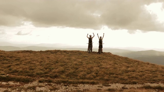 山地车手高举在山脊上视频素材