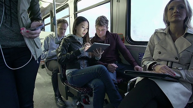 在公交车上玩平板电脑的通勤者视频下载