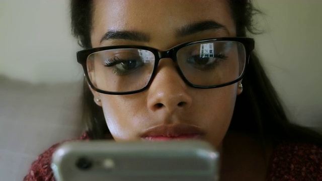 眼镜反射手机屏幕。年轻女子,关闭。视频下载
