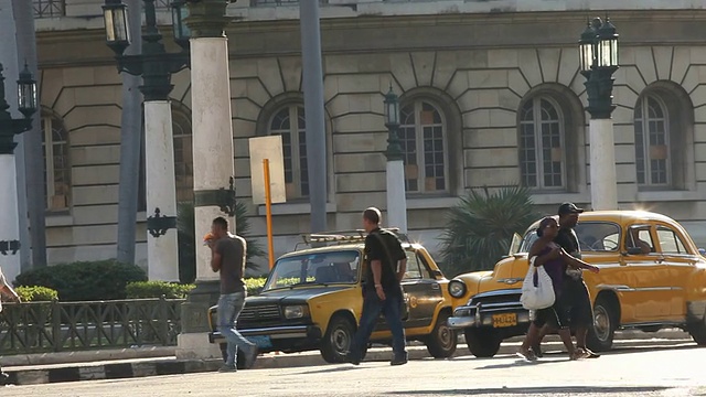 繁忙的交通，老式的美国汽车和古巴哈瓦那的行人视频下载