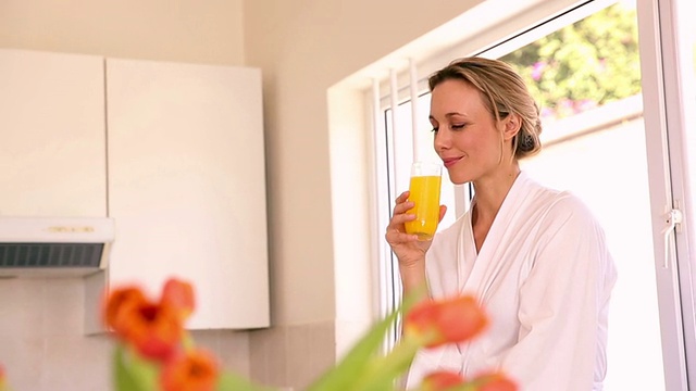 早上喝橙汁的快乐女人视频素材