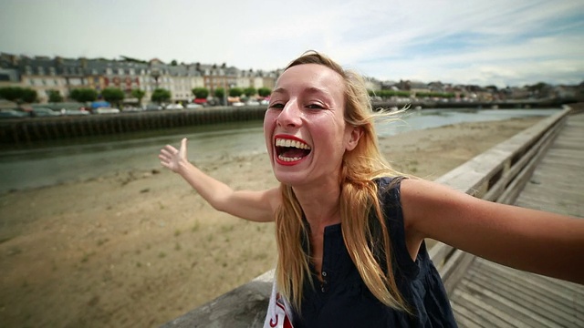 一名年轻女子在法国诺曼底的特卢维尔港自拍视频下载