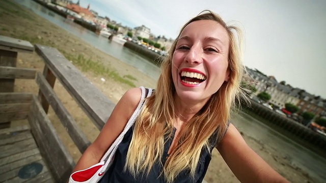 一名年轻女子在法国诺曼底的特卢维尔港自拍视频下载