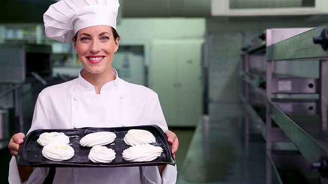 快乐的厨师对着镜头微笑展示一盘蛋白酥皮视频素材