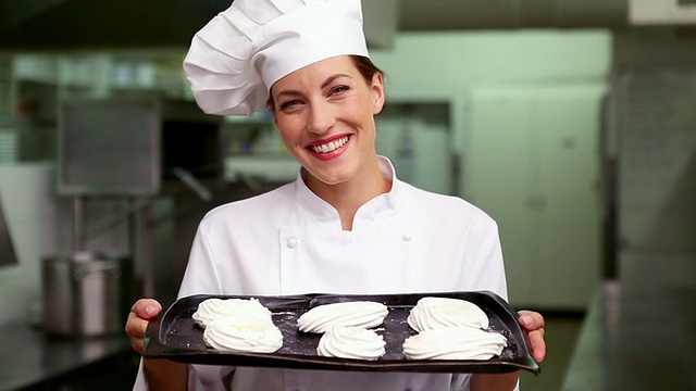 快乐的厨师对着镜头微笑展示一盘蛋白酥皮视频素材