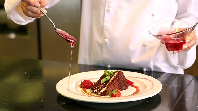 厨师将草莓酱浇在巧克力蛋糕上视频素材