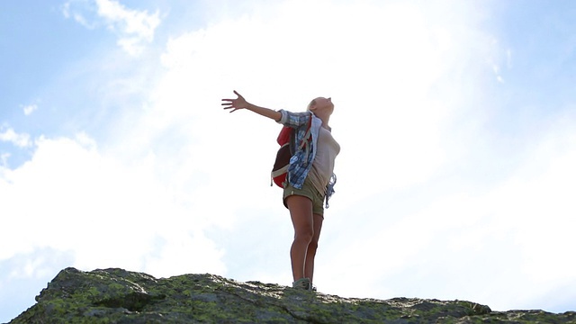 年轻女子徒步攀登山峰-成功和自由视频素材