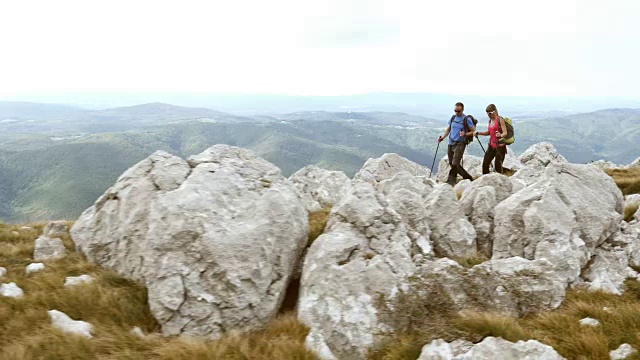 一对夫妇徒步攀登山顶的航拍视频素材