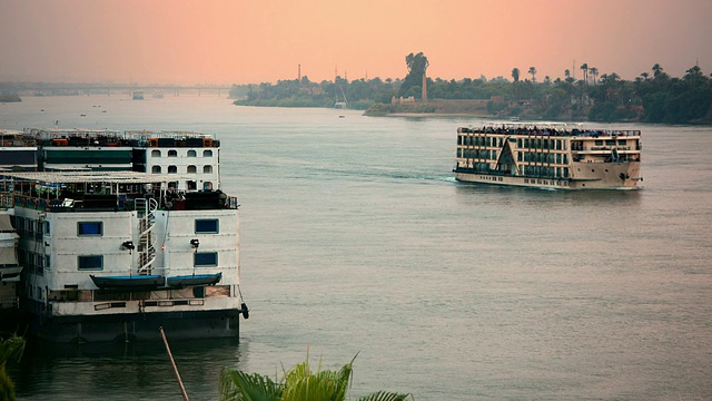 日落时分，尼罗河游船在埃及卢克索附近视频下载