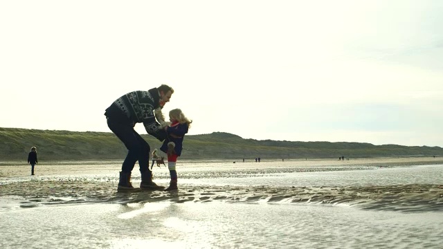 父亲和女儿在海滩上享受视频下载