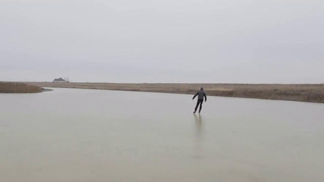 美国蒙大拿州，一名年轻人冬天在结冰的池塘上滑冰。视频素材