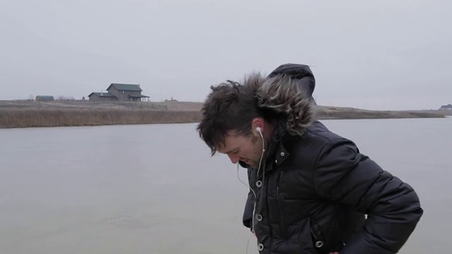 在美国蒙大拿州的乡下，一个年轻人在结冰的池塘上吹气。视频下载