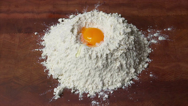 鸡蛋落到面粉上的慢镜头视频素材