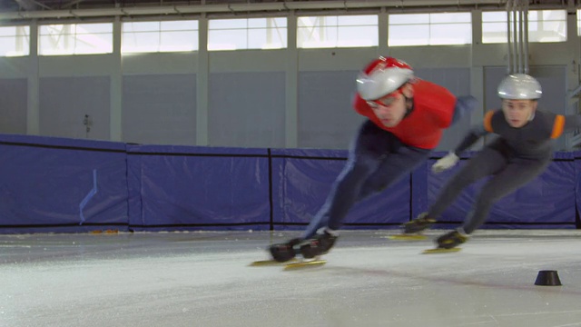 三名短道速滑选手在冰场比赛中转弯视频下载