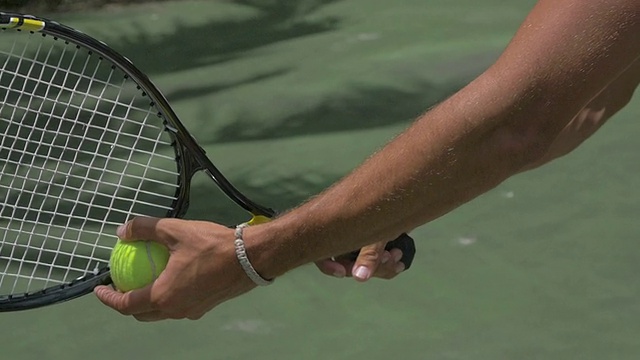 一个年轻人拿着网球拍的特写镜头。——慢动作视频下载
