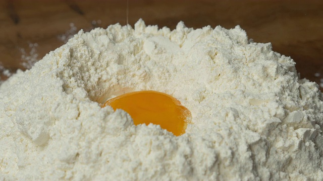 鸡蛋落到面粉上的慢镜头视频素材
