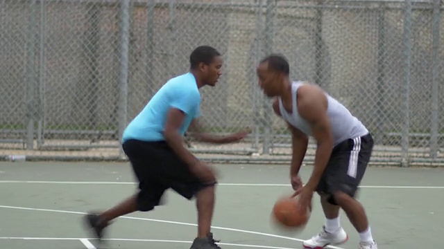 两个年轻人在一对一打篮球。视频下载