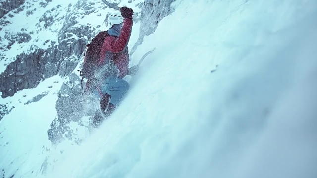 冬季登山者挥舞着他的斧头爬上积雪的斜坡视频素材
