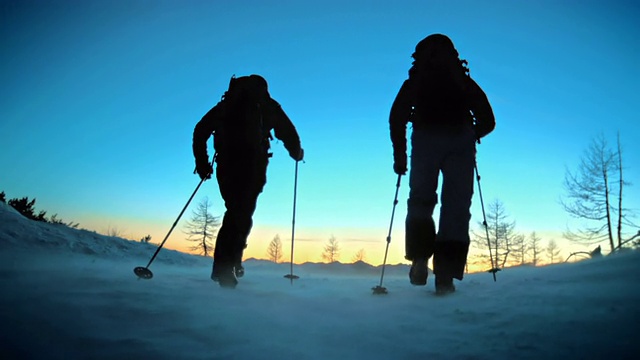 SLO MO TS登山运动员在雪山上行走的剪影视频素材
