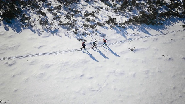 空中滑雪游客沿着山间小路滑雪视频下载