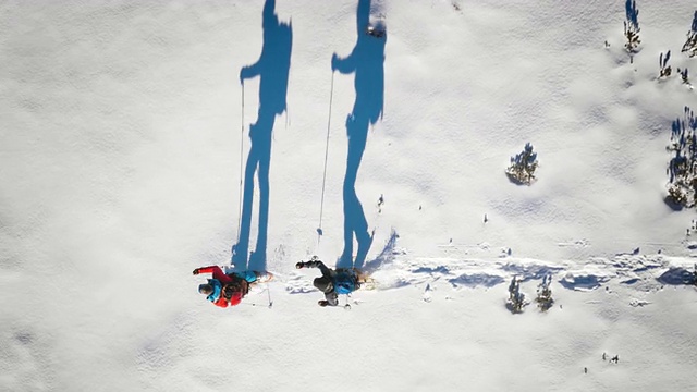 空中的登山者和他们的剪影雪鞋在阳光明媚的日子视频素材