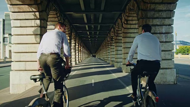贝西桥的跟踪镜头，两个骑自行车的人经过视频下载