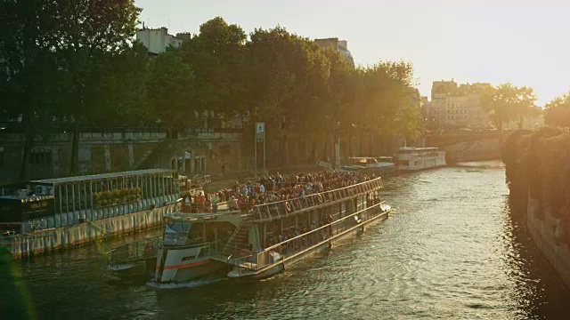 在夕阳下，一艘船通过塞纳河和巴黎圣母院视频素材