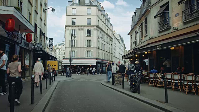 跟踪拍摄典型的巴黎街道，有酒吧和cafés，行人视频下载