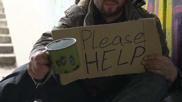 高清多莉:无家可归的人摇晃他的杯子视频素材