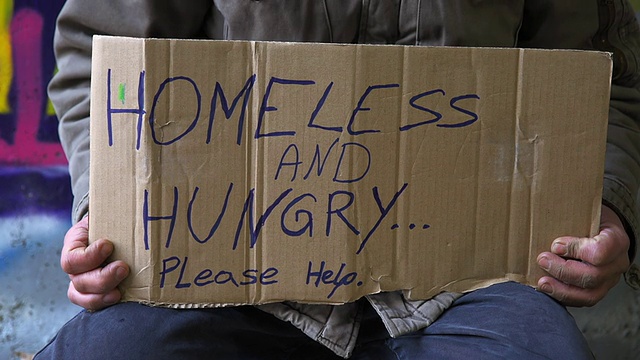 无家可归的人跪在纸板上视频素材