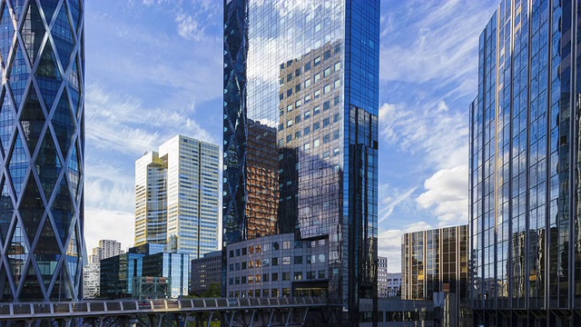跟踪和平移拍摄时间流逝在金融/商业区摩天大楼与云反射视频素材