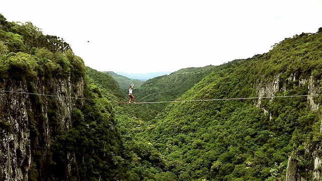 人们穿越高悬的峡谷，瀑布视频素材