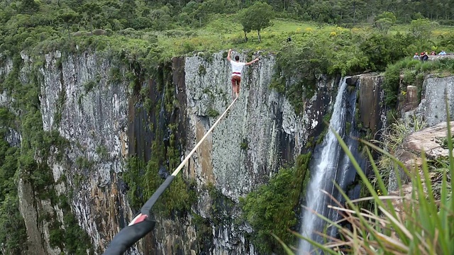 人们穿越高悬的峡谷，瀑布视频素材