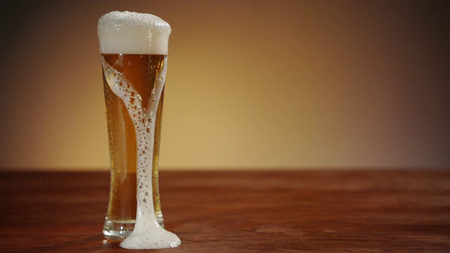 啤酒被倒进玻璃杯，慢慢溢出视频素材