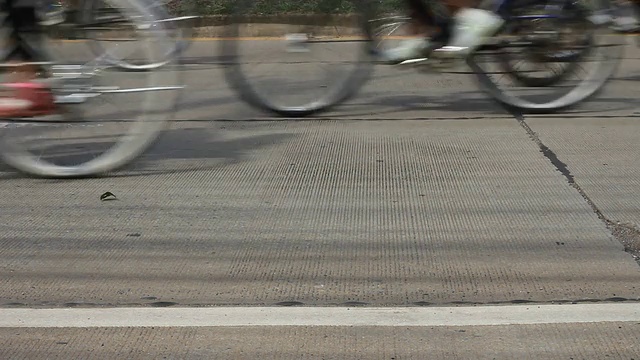 模糊了道路上的许多自行车轮子。视频素材