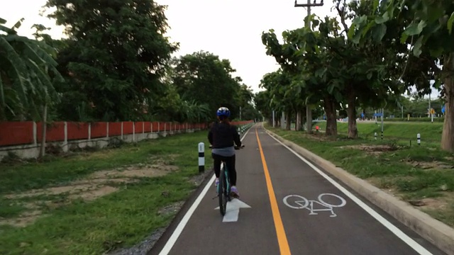 在自行车道上骑自行车的妇女视频下载