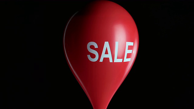 SLO MO红色水填充气球与销售标志爆炸视频素材