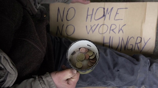高清慢镜头:乞丐摇晃他的零钱杯视频素材