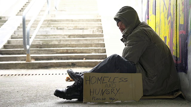 路人给无家可归的人零钱视频素材