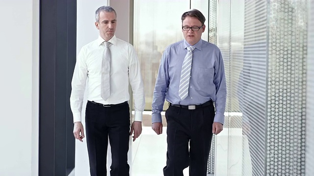 两个男同事走在走廊上聊天视频素材