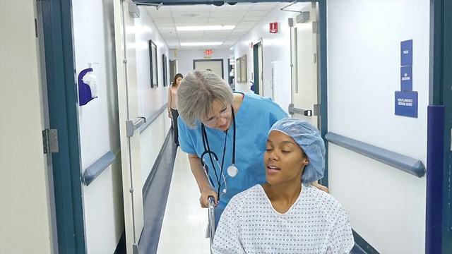 高级护士在医院走廊推病人视频素材