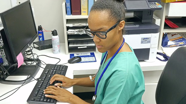 年轻的非裔美国护士在护士站接听电话视频下载