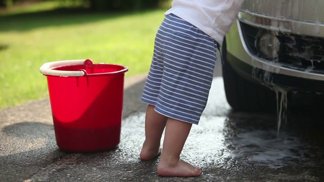 可爱的小男孩正在洗车视频下载