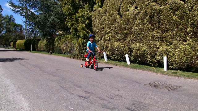 HD:小男孩用稳定器学习骑自行车视频素材