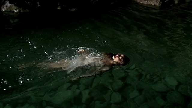 女人在一个天然的游泳池里跳水和游泳视频下载