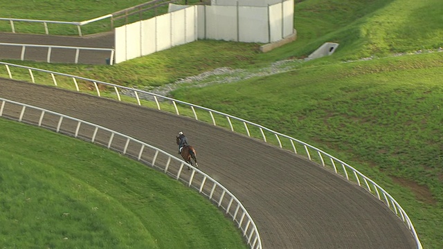 在美国肯塔基州凡尔赛的WinStar赛道上拍摄的马的跑道和拉出的马进入转弯视频素材