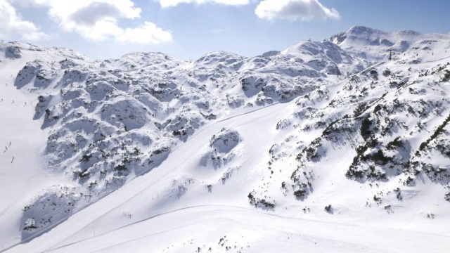 空中滑雪者在阳光明媚的日子从山坡上滑雪视频素材