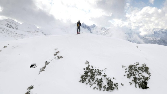 空中滑雪旅行者得意洋洋地在山顶举起双手视频素材